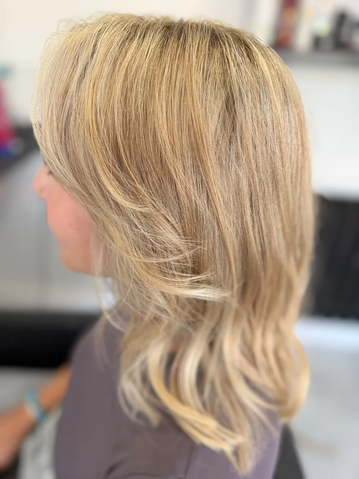 Layered blonde hair with a soft feathered finish, styled by Lois